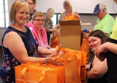 Members of the People First of Missouri Steering Committee are pictured preparing for SOAR conference by filling conference goodie bags.