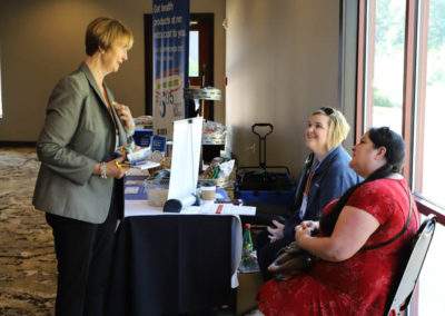 Conference attendees and United Health Care representatives are pictured having a candid conversation with one another.
