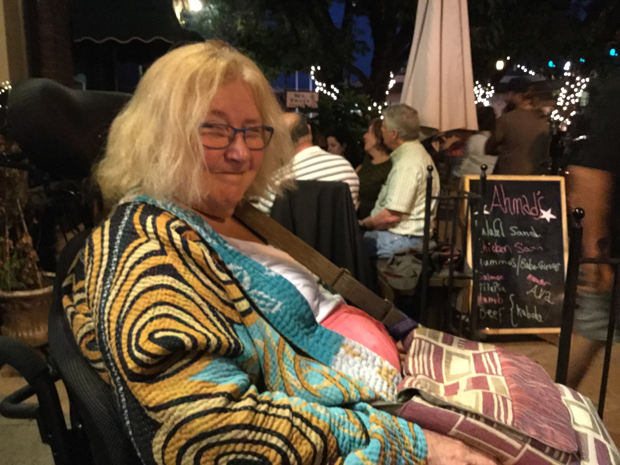 Photo of Kathy Hoell. She is sitting in a restaurant and smiling.