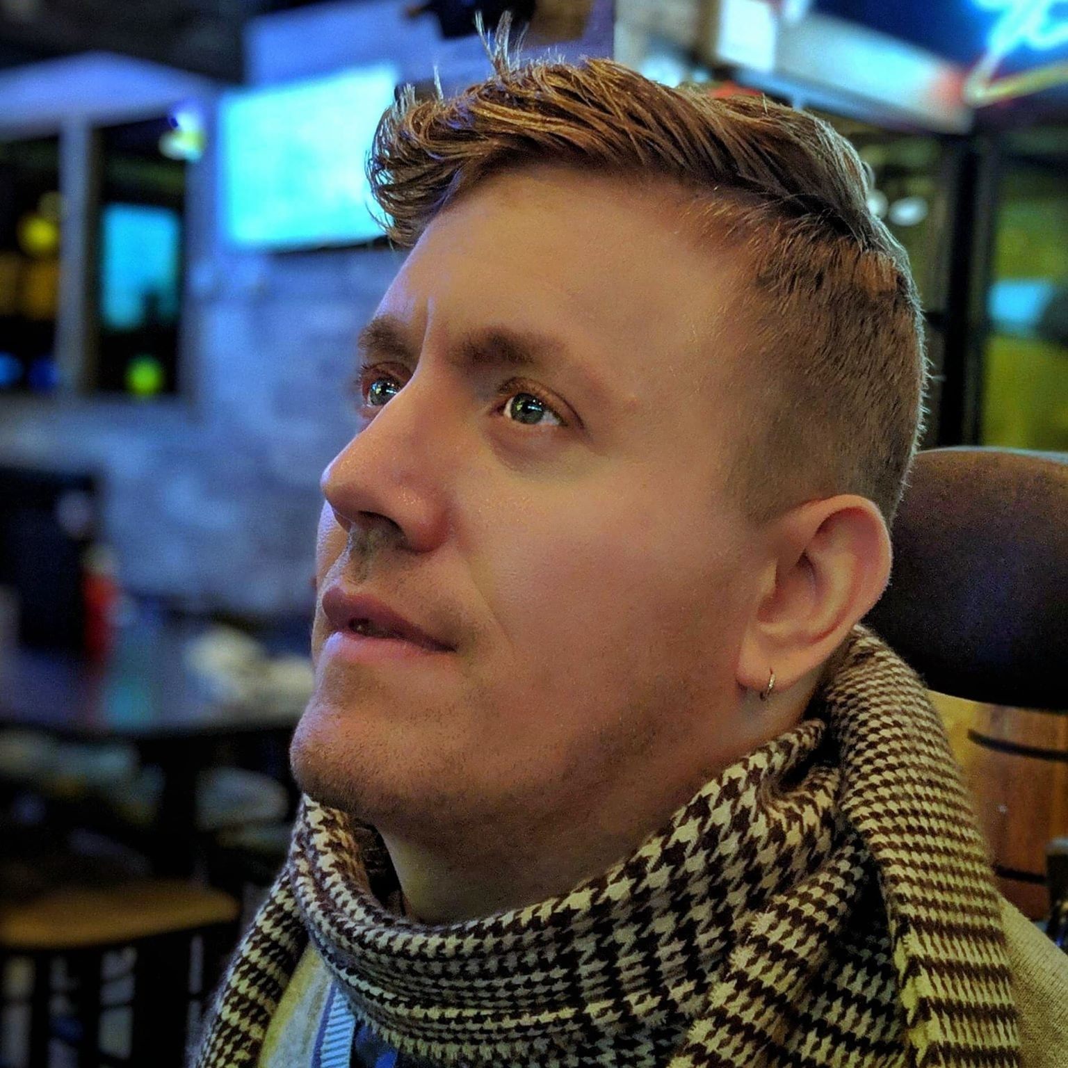 Photo of Tucker Cassidy. He is sitting in a restaurant and smiling.