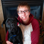 Photo of Julie Mueller with her dog. They are both sitting in a chair together.